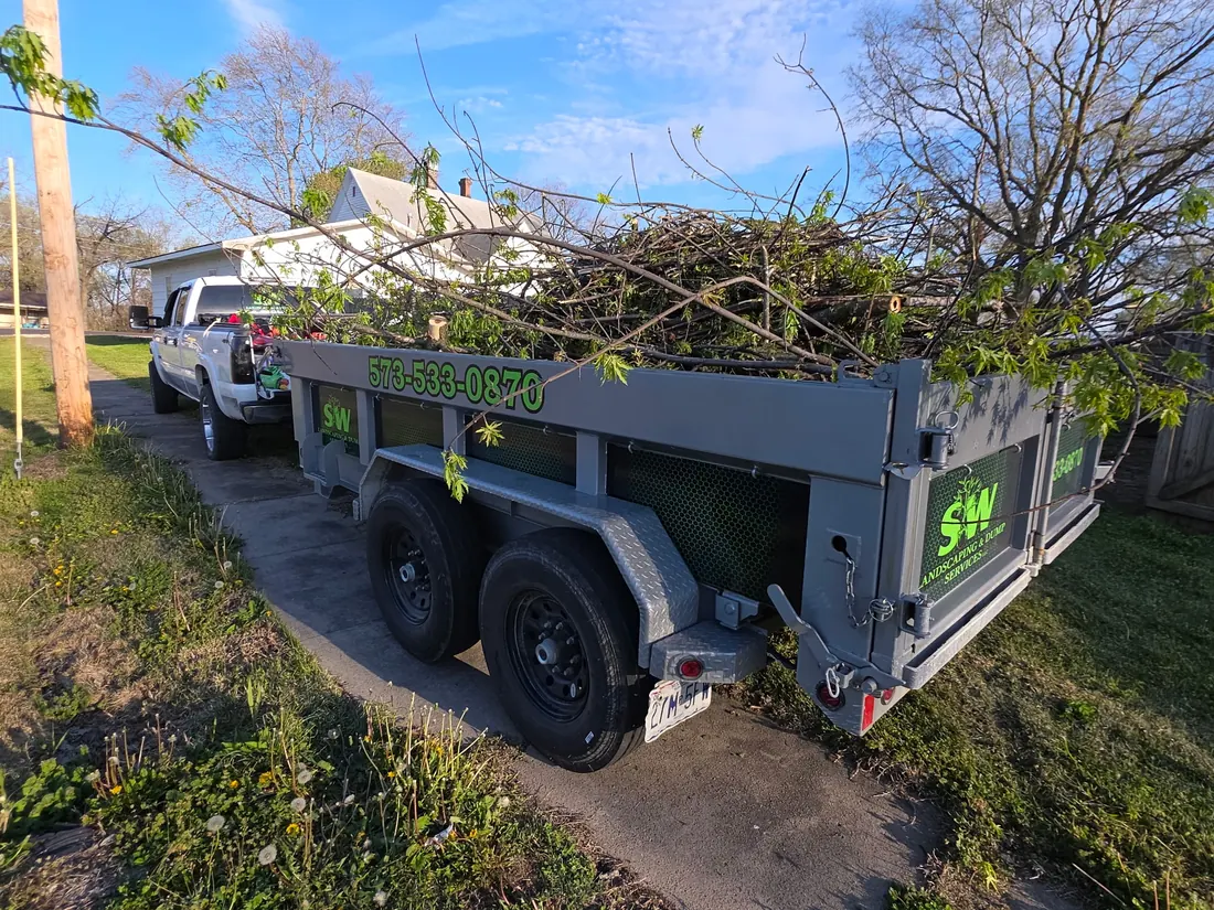 SW Landscaping dump trailer loaded with brush after cleanup work
