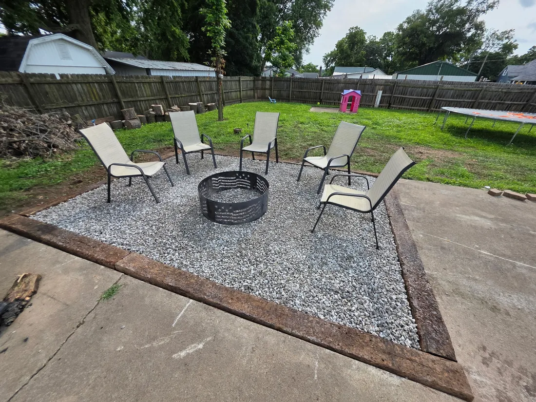 Backyard firepit sitting area with fresh gravel, edging, and chairs