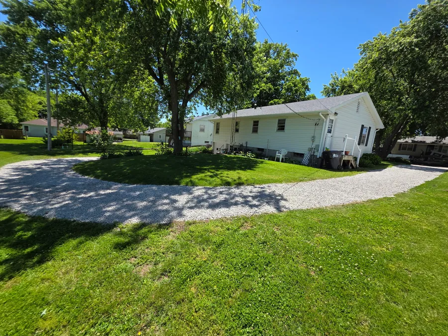 Fresh gravel driveway and parking area bordered by lawn