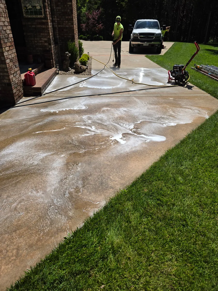Pressure washing work cleaning a concrete driveway